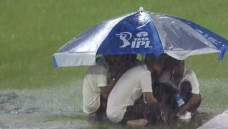 IPL 2023: Ground staff at Narendra Modi Stadium take cover beneath an umbrella as heavy rain stops play