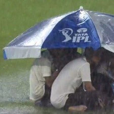 IPL 2023: Ground staff at Narendra Modi Stadium take cover beneath an umbrella as heavy rain stops play